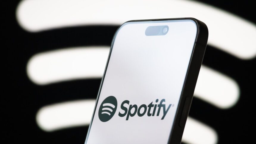 Spotify. logo displayed on smartphone screen. Cheng Xin/Getty Images